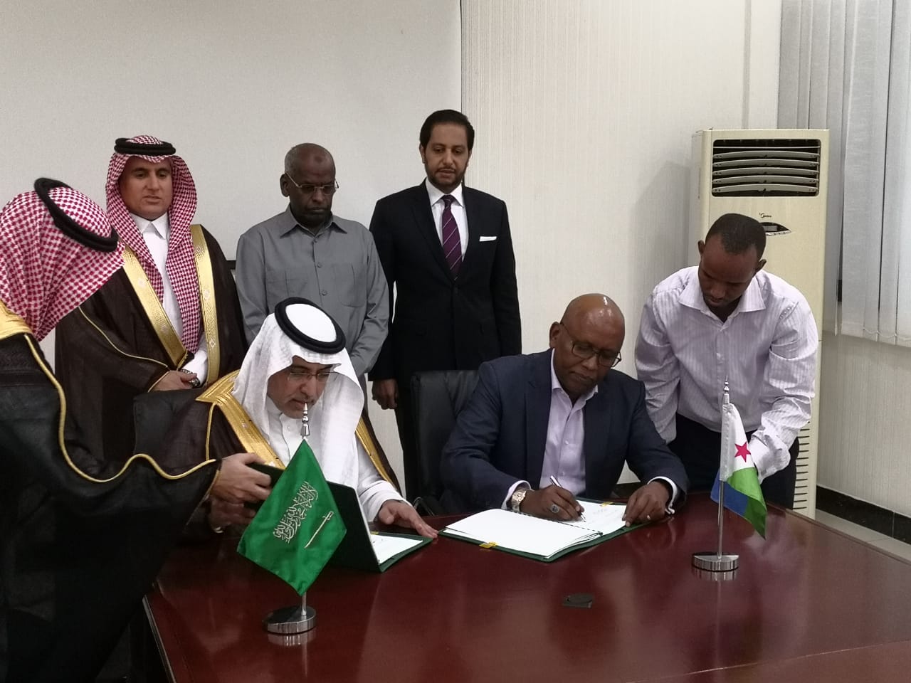 The Vice Chairman of the Saudi Fund for Development, Dr. Khalid bin Sulaiman Al Khudairy (pictured left) and the Djibouti Minister of Economy and Finance, Mr Elias Moussa Doula (right) sign a new grant agreement in the presence of the Prime Minister of Djibouti, Mr. Abdoulkader Kamil Mohamed (center back row) which will help finance new infrastructure development projects in Djibouti. (Photo : AETOSWire)