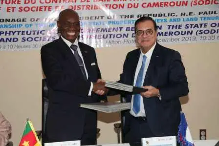 Echange de documents entre le ministre Henri Eyebe Ayissi (à gauche) et le PDG de Mercure Adnan  Houdrouge (à droite).