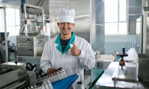 Mehmet Tulti Abudureyimu stands in front of an automatic production line of nangs, a traditional pancake, in a village cooperative in Keping county, Xinjiang. Although he is young, he has become the master of the production line. (Photo by Shan Jie from Global Times)