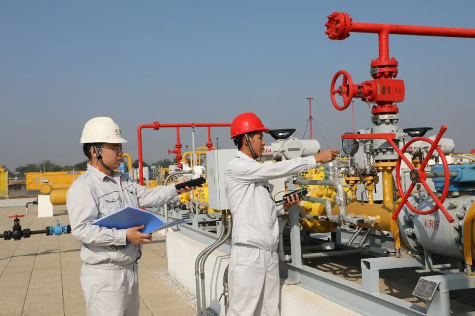 Chinese and Burmese workers test the equipment at the distribution station of China-Myanmar oil and gas pipelines in Mandalay, Myanmar. (Photo by Sun Guangyong from People’s Daily)