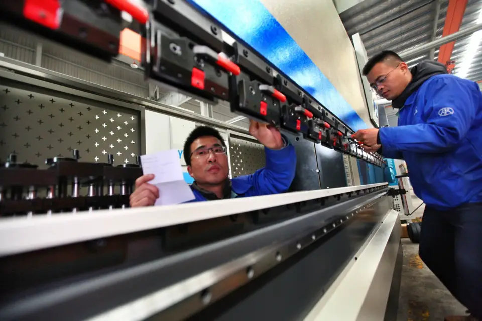 On Dec. 24, 2019, technicians assemble high-end CNC machine tools for export at a manufacturing workshop in Ma'anshan, east China's Anhui province. (Photo by Wang Wensheng, People's Daily Online)