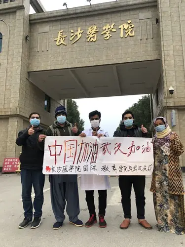 Usman and his students from various countries at the campus of Changsha Medical University (CMU) hold a banner to cheer on Chinese amid the novel coronavirus outbreak. (Photo: Courtesy of CMU)