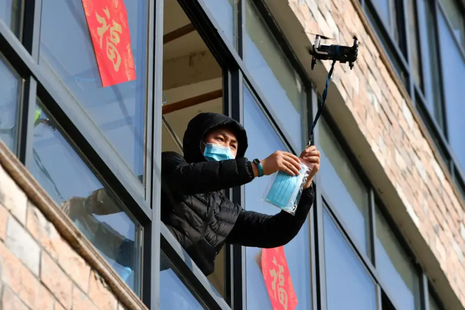 A man in home quarantine in Changping village, Jiapu town, Changxing county, Huzhou, east China’s Zhejiang province, receives face masks and thermometer delivered by a drone on Feb.9, 2020. (Photo by Tan Yunfeng/People’s Daily Online)
