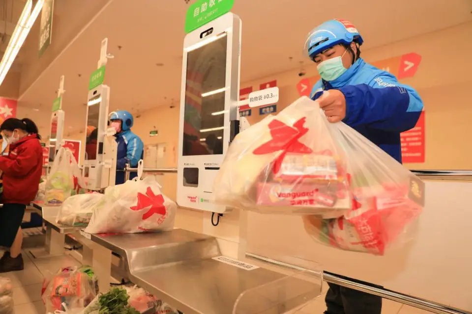 Couriers fetch commodities from a supermarket in Zhoushan, east China’s Zhejiang province, Feb. 10, 2020. Photo by Chen Yongjian, People’s Daily Online