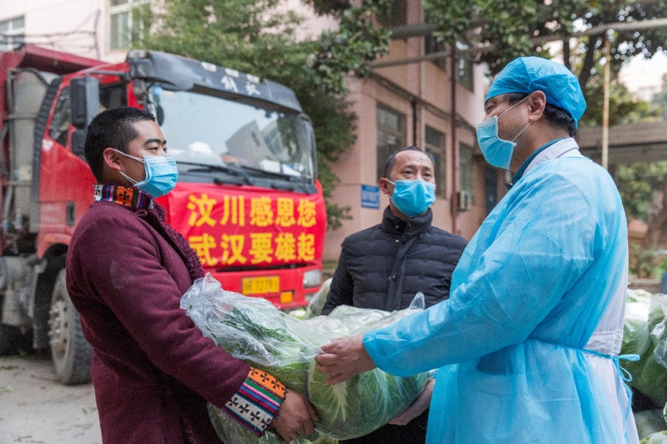 Zhao Yong, Chief of Longzhu village, Wenchuan county of Sichuan province and his fellow villagers deliver vegetables to a medical staff in Wuhan, Feb. 5. The man, together with 12 of his fellow villagers, have donated vegetables to 12 major hospitals in the city. (Photo by Zhang Wujun/People’s Daily) Zhao Yong, Chief of Longzhu village, Wenchuan county of Sichuan province and his fellow villagers deliver vegetables to a medical staff in Wuhan, Feb. 5. The man, together with 12 of his fellow villagers, have donated vegetables to 12 major hospitals in the city. (Photo by Zhang Wujun/People’s Daily)