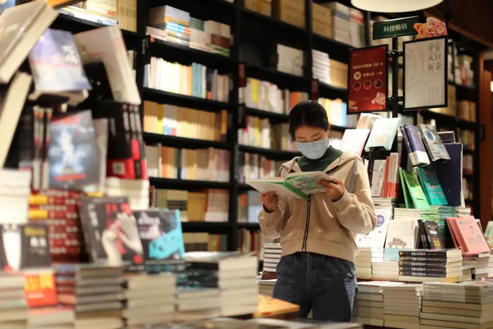 A woman in southwest China’s Chongqing municipality reads a book in a bookstore, March 18, 2020. With continuous efforts to maintain strict epidemic prevention and control measures while promoting resumption of work and production, brick-and-mortar bookstores in Chongqing have resumed business one after another. Some bookstores in the city have rolled out book delivery services to better meet the demands of consumers. (Photo by Sun Kaifang/People’s Daily Online)