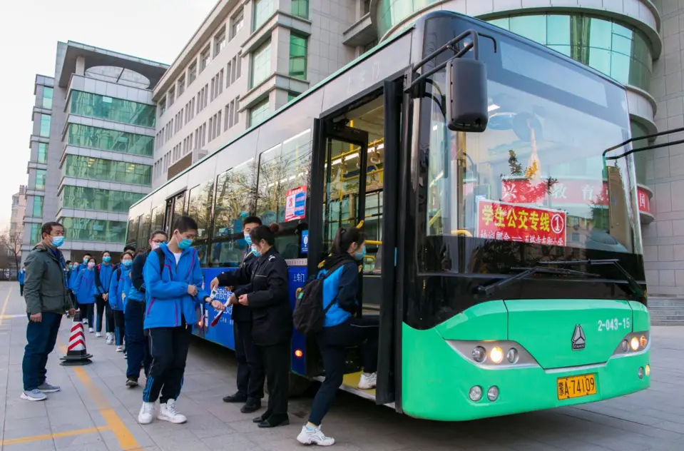 On April 8, 2020, the safety officer took the temperature of the students who took the bus line of No. 26 Middle School in Hohhot and registered the temperature. © Ding Genhou / People’s Daily Online