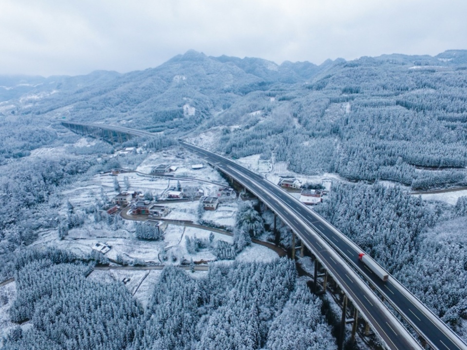 Photo shows the G76 Xiamen–Chengdu Expressway spanning the Wumeng Mountain range blanketed with white snow. (Photo by Li Xin, People’s Daily Online)