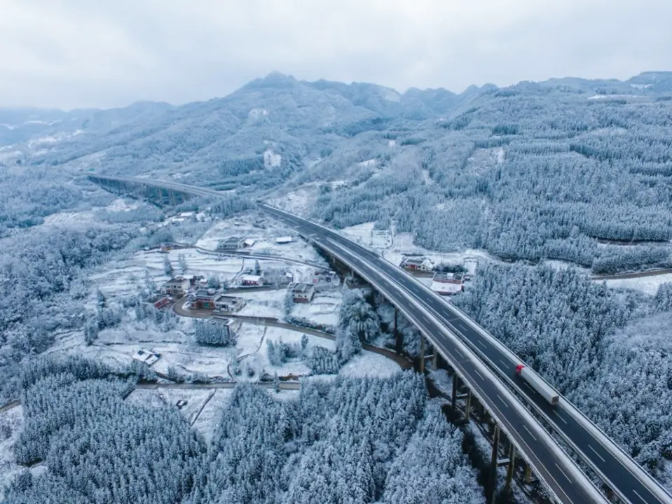 Photo shows the G76 Xiamen–Chengdu Expressway spanning the Wumeng Mountain range blanketed with white snow. (Photo by Li Xin, People’s Daily Online)
