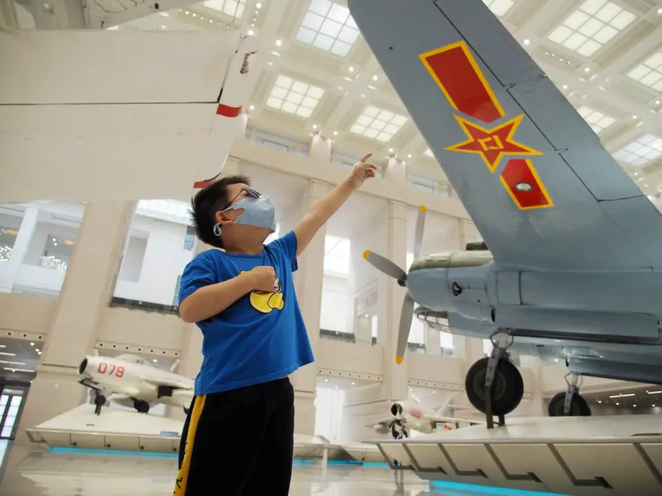 A boy observes helicopters exhibited in the Military Museum of the Chinese People’s Revolution, May 6, 2020. (Photo by Du Jianpo/People’s Daily Online)