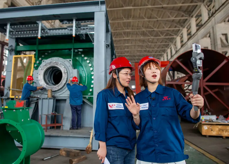 Employees with Jiangsu Pengfei Group Co., Ltd. introduce its manufacturing process to customers from both home and abroad via the live-streaming platform under the Canton Fair, June 15. (By Zhai Huiyong/People’s Daily Online)