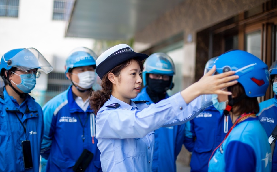 A policewoman in Hai'an, east China's Jiangsu province, instructs deliverymen on helmet-wearing tips. (By Zhai Huiyong, People's Daily Online) A policewoman in Hai'an, east China's Jiangsu province, instructs deliverymen on helmet-wearing tips. (By Zhai Huiyong, People's Daily Online)