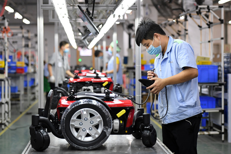 A worker of Chiaphua Components (Jiangxi) Limited. assembles electric wheelchairs in Fengcheng city, east China’s Jiangxi province, July 3. (Photo by Zhou Liang, People’s Daily Online)