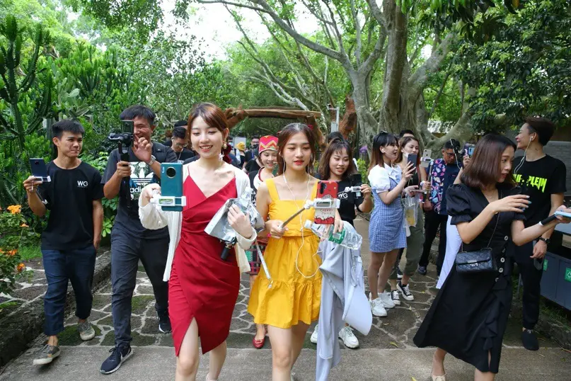 Photo taken on June 25 shows popular livestreaming hosts introducing a scenic spot in Haikou, capital of South China’s Hainan Province. (Photo by Zhang Mao/People’s Daily Online)