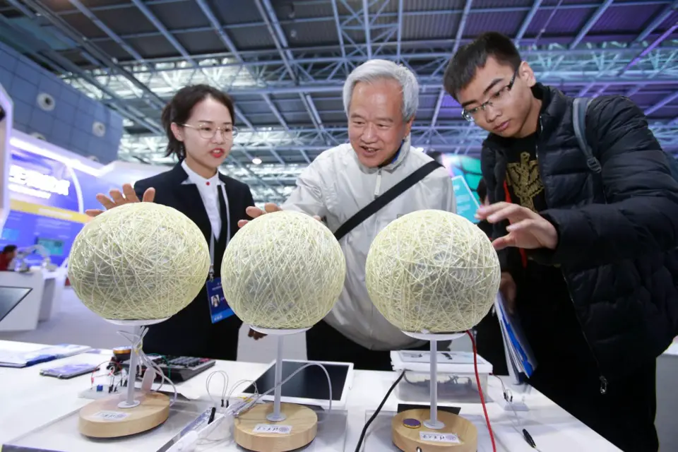 A staff member (L1) introduces vapor power generation at the Zhongguancun International Frontier Science and Technology Achievements Exhibition held at the Zhongguancun Exhibition Center, Zhongguancun Science Park, Beijing. Photo by Chen Xiaogen/People’s Daily Online