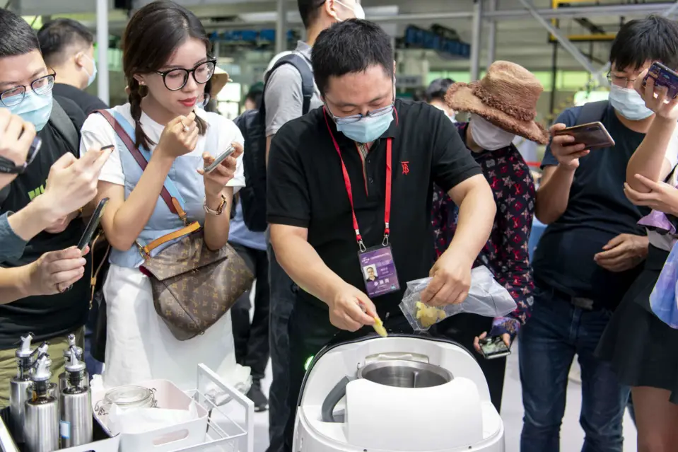 An exhibitor demonstrates the functions of a robot chef to journalists in the service robots exhibition zone of the thematic exhibition pavilion of the 2020 China International Fair for Trade in Services (CIFTIS), Spet.1. (Photo by Weng Qiyu/People’s Daily Online)