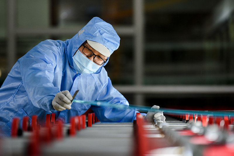 A man works on the production line of a glass manufacturer in Jingzhou, central China's Hubei province, Sept. 14. Photo by Huang Zhigang/People's Daily Online