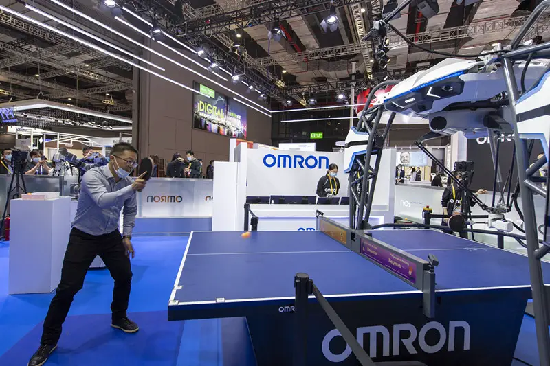 A participant plays ping-pong with a ping-pong-playing robot from Japanese technology company Omron at the technical equipment exhibition area of the third China International Import Expo in east China’s Shanghai, Nov. 5, 2020. (Photo by Weng Qiyu/People’s Daily Online)