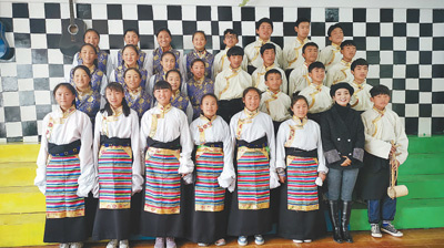 A group photo of Padma Qogco (second from right) and students in the school choir of Yanjing Middle School. (File photo)