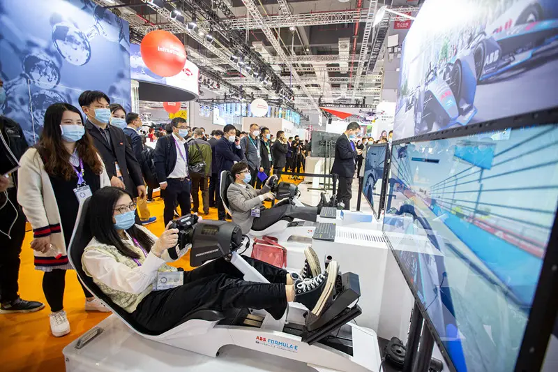 Visitors try the Formula E race simulators of the tech giant ABB Group from Switzerland during the third China International Import Expo, Nov. 6. (Photo by Zhai Huiyong/People’s Daily Online)