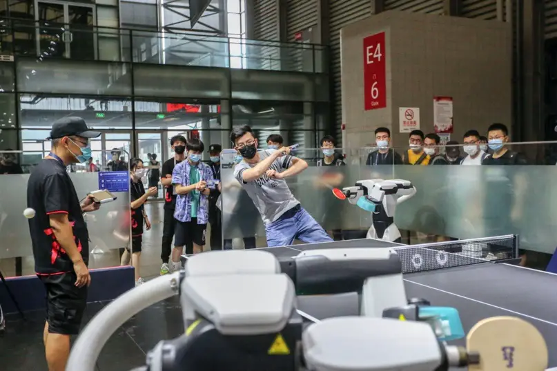 A visitor plays table tennis with a ping-pong robot Pong-bot at the ChinaJoy game event in Shanghai, July 31. (Photo by Wang Chu/People’s Daily Online)