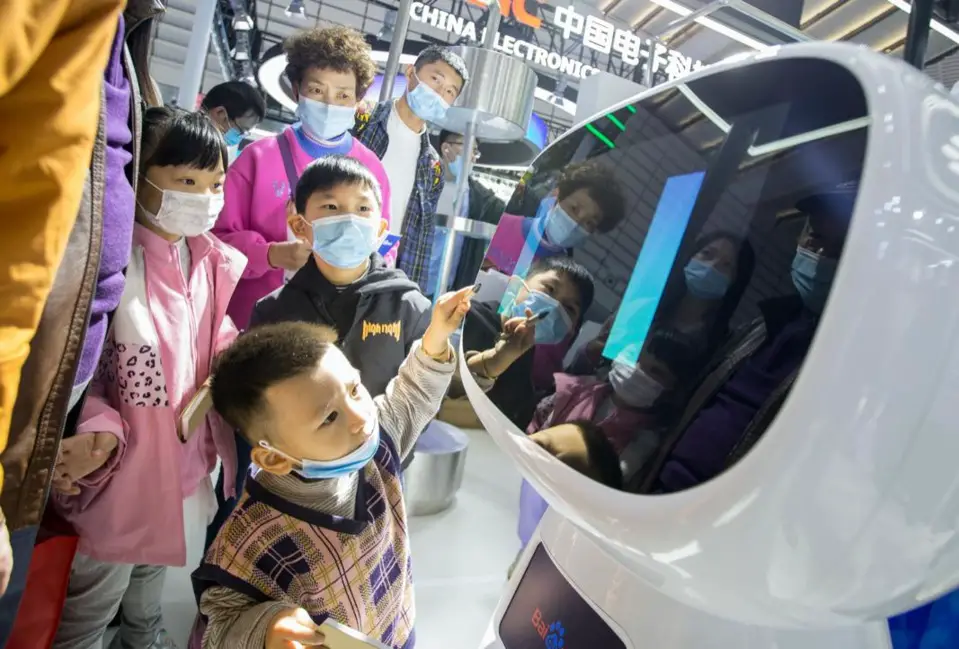 Children interact with Xiaodu, a smart robot rolled out by Chinese search engine giant Baidu, during the Light of Internet Expo of the 2020 WIC, Nov. 22. (Photo by Zhai Huiyong/People's Daily Online)