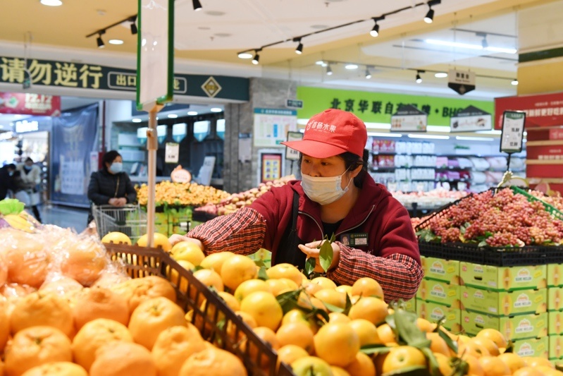 A staff member organizes the fruits at a supermarket in Renhuai City, Southwest China’s Guizhou Province on December 15. Photo by Chen Yong/People’s Daily Online
