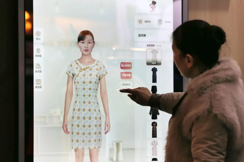 A customer tries on cloths with the help of a smart dressing mirror at Xiaohuagua Garment E-commerce Co., Ltd. in Suixi county, east China’s Anhui province. (Photo by Wan Shanchao/People’s Daily Online)