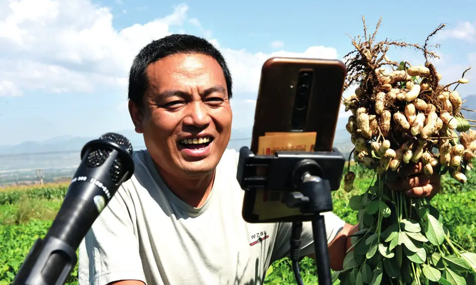 A farmer promotes his peanuts on a livestreaming app in Hebei Province. Photo: IC