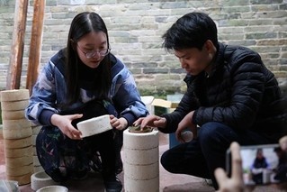 Tu Jinge (left) talks with a craftsman about technological process of making porcelain leaf cups. (Photo/Courtesy of Tu Jinge) Tu Jinge (left) talks with a craftsman about technological process of making porcelain leaf cups. (Photo/Courtesy of Tu Jinge)