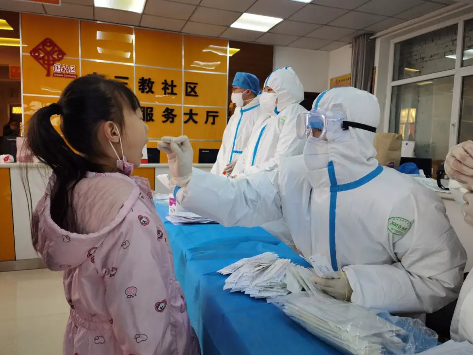 A girl receives COVID-19 nucleic acid test at a designated testing site in Shijiazhuang, north China’s Hebei province, Jan. 6. (Photo by Lv Lining/People’s Daily Online)