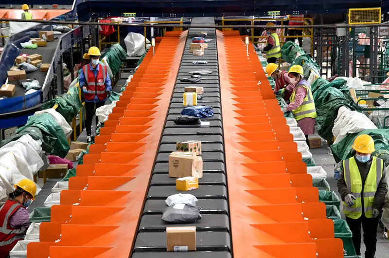 Employees of Handan branch of China Post work by an automatic sorting belt, Nov. 9, 2020. (Photo by Hao Qunying/People's Daily Online)