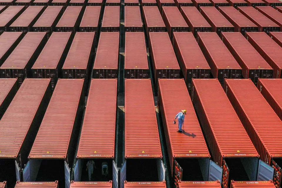 Employees of a container manufacturer paint and check containers in Nansha District, Guangzhou, south China's Guangdong Province, Feb. 3, 2021. (Photo by Qiu Xinsheng/People's Daily Online)