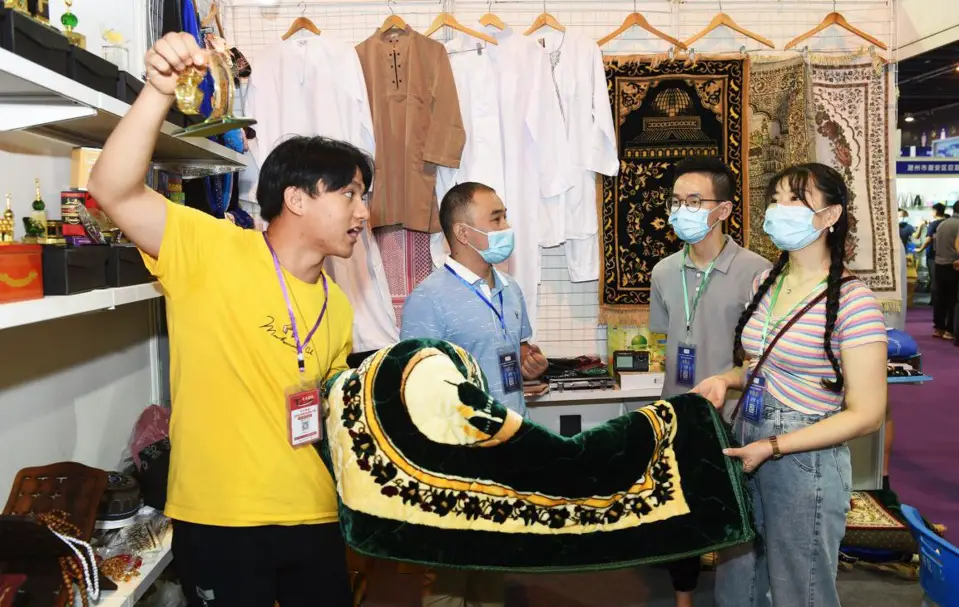 Merchants purchase a batch of carpets scheduled to be exported to Arab countries at the third China (Yiwu) Cross-Border E-Commerce Industrial Belt Expo, Sept.13, 2020. (Photo by Gong Xianming/People's Daily Online)