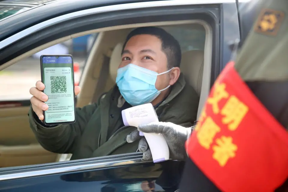 Photo taken shows a citizen in Changzhou, east China’s Jiangsu province, showing his digital health code to a volunteer at the gate of a residential complex. (Photo by Chen Wei/People’s Daily Online)