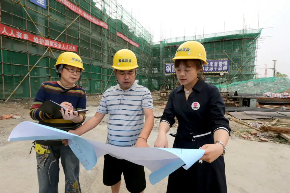 Wang Xiaomei (left), a deputy to the National People's Congress, investigates the construction of livelihood projects at a construction site of a kindergarten expansion project in Qingshen County, Meishan, southwest China's Sichuan Province, ahead of the 2020 "two sessions," May 14, 2020. (Photo by Zhang Zhongping/People's Daily Online)
