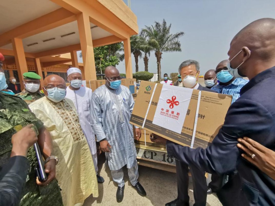 A batch of China-donated COVID-19 vaccines arrive in Conakry, capital of Guinea, March 3. Photo shows an official with the Chinese Embassy in Guinea delivering the vaccines to the Guinean side. (Photo from the Chinese Embassy in Guinea)