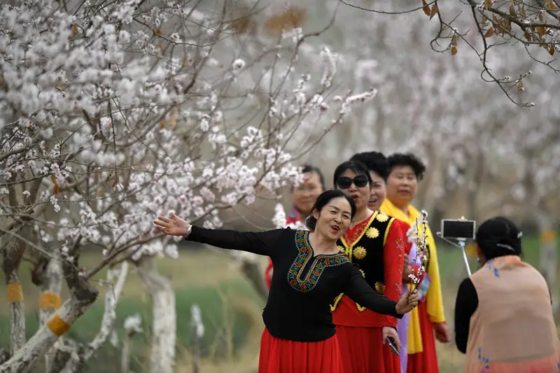 Visitors pose for a photo in an agricultural park in Luntai County, northwest China's Xinjiang Uygur Autonomous Region, March 27, 2021. (Photo by Chue Hurre/People's Daily Online)