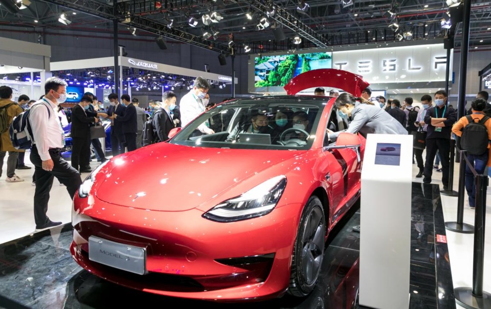 Visitors are attracted to a Tesla Model 3 electric car exhibited at the automobile exhibition area of the third China International Import Expo held in east China’s Shanghai, Nov. 6, 2020. (Photo by Zhai Huiyong/People’s Daily Online)