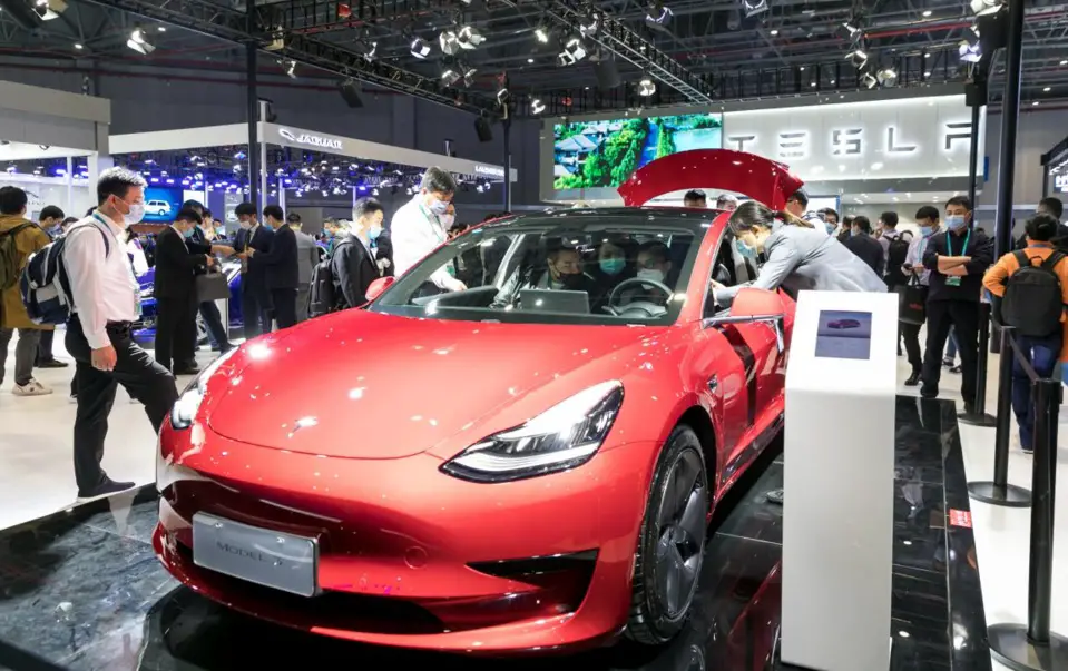 Visitors are attracted to a Tesla Model 3 electric car exhibited at the automobile exhibition area of the third China International Import Expo held in east China’s Shanghai, Nov. 6, 2020. (Photo by Zhai Huiyong/People’s Daily Online)