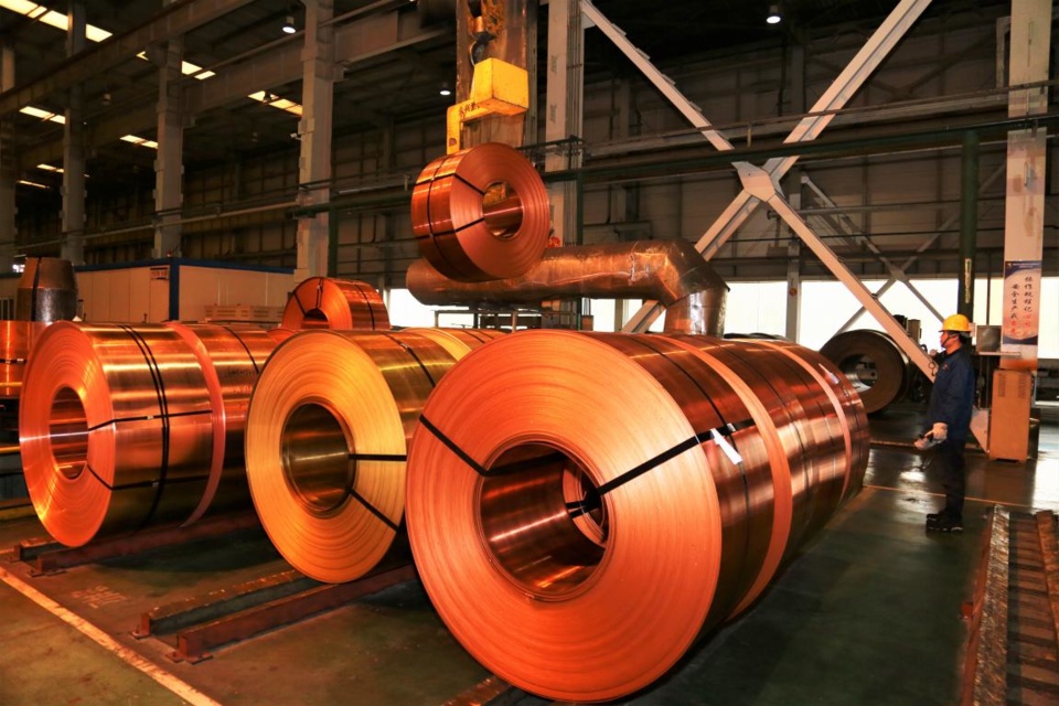 A worker lifts copper belts with a bridge crane at a workshop of Tongling Jinvi Copper Corp, a branch of the Tongling Nonferrous Metals Group Holdings Co., Ltd., east China's Anhui Province, Feb. 23, 2021. (Photo by Pan Wei/People's Daily Online)