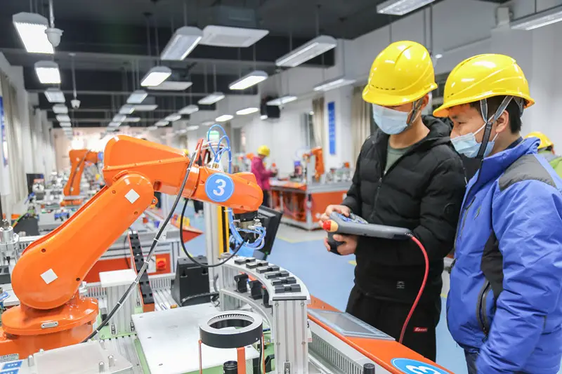 Photo shows trainees are learning to control industrial robot during a training course on industrial robot operation and maintenance. The first session of the training course kicked off at the Xinqiao vocational school in Songjiang district, Shanghai, on March 7, 2021, involving a total of 40 trainees. (Photo by Jiang Huihui/People’s Daily Online)