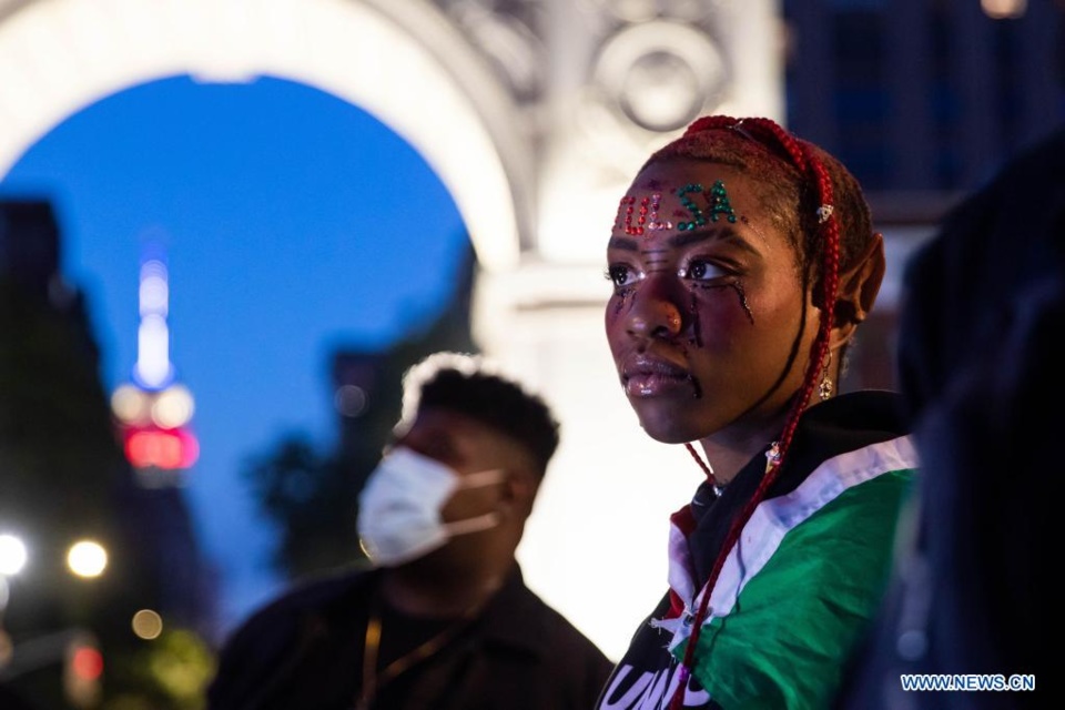 A woman with Tulsa displayed on her forehead attends an event in remembrance of the 100th year anniversary of the 1921 Tulsa Race Massacre, in New York, United States, May 31, 2021. The city of Tulsa is commemorating the 1921 Tulsa Race Massacre centennial on Monday with events and ceremonies to honor the victims. On the night of May 31, 1921, a white mob descended the prosperous, all-black neighborhood of Greenwood in north Tulsa. In less than 24 hours, the mob burned what had been known as "Black Wall Street" to the ground leaving more than 10,000 residents homeless. The exact death toll was not recorded, but an estimated 300 people died in the tragedy. Historians believed that mass graves could be located within the city where digging is conducted. (Xinhua/Michael Nagle)