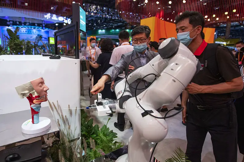 Visitors look at a full-automatic nasopharyngeal swab sampling robot exhibited at the 2021 China International Fair for Trade in Services in Beijing, China, Sept. 5, 2021. (Photo by Weng Qiyu/People’s Daily Online)