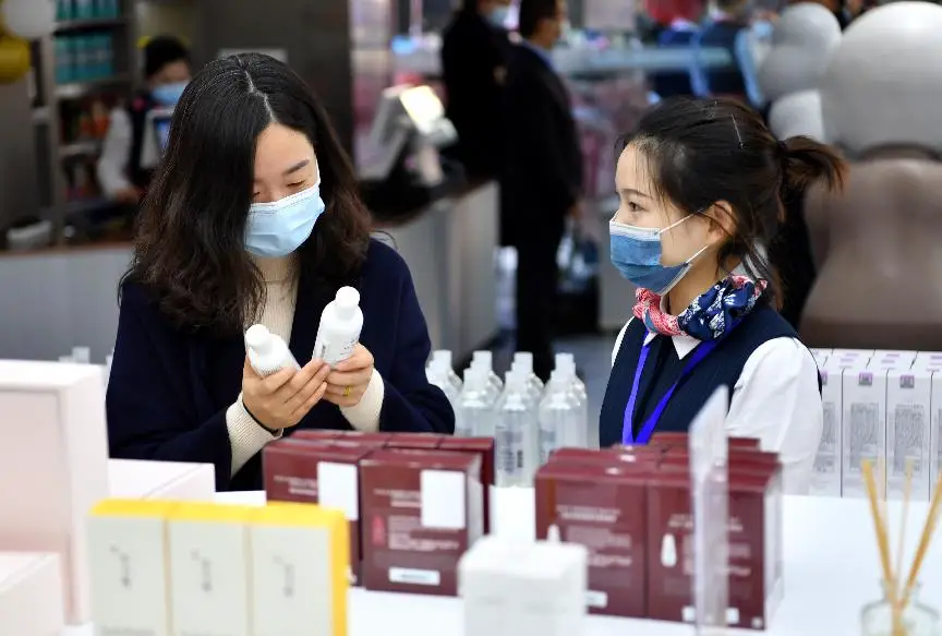 A woman buys products at a store selling bonded commodities imported by the China-Europe freight train service in Nanchang, east China's Jiangxi province, Feb. 20, 2021. (Photo by Shi Yu/People's Daily Online)