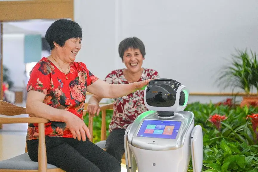 Seniors experience a nursing robot at a nursing home in Huzhou, east China's Zhejiang province, June 2, 2020. (Photo by Liu Chunhui/People's Daily Online)