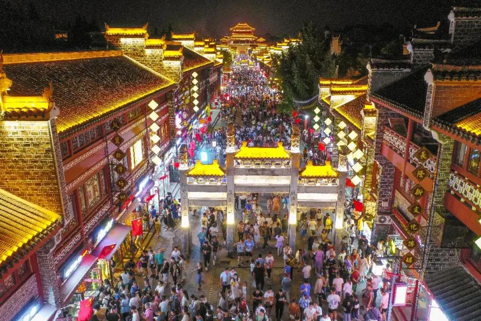 Photo taken on Oct. 3, 2021 shows tourists at the illuminated Xiangyang ancient town, Xiangyang city, central China’s Hubei province. (Photo by Yang Dong/People’s Daily Online)