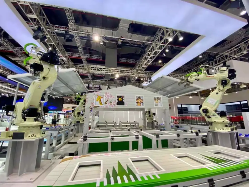 Four robots assemble a house at the exhibition booth of Japanese industrial robot manufacturer Nachi-Fujikoshi at the 4th China International Import Expo, Nov. 4, 2021. (Photo by Ju Yunpeng/People's Daily)