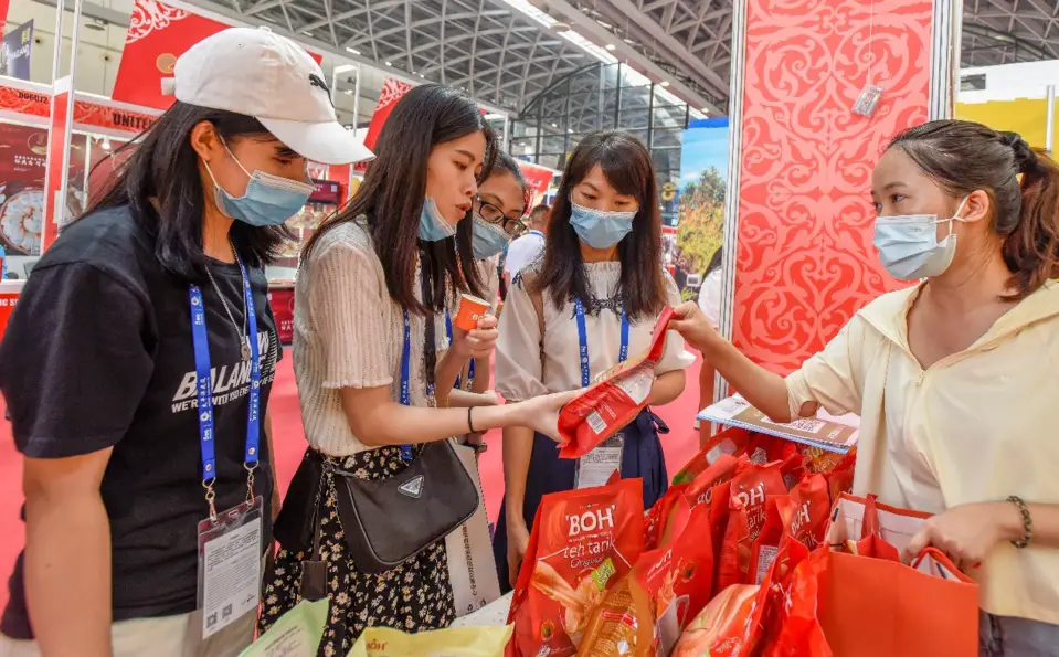 Visitors learn about Malaysian coffee at the 18th China-ASEAN Expo, Sept. 10, 2021. (Photo by Peng Huan/People’s Daily Online)