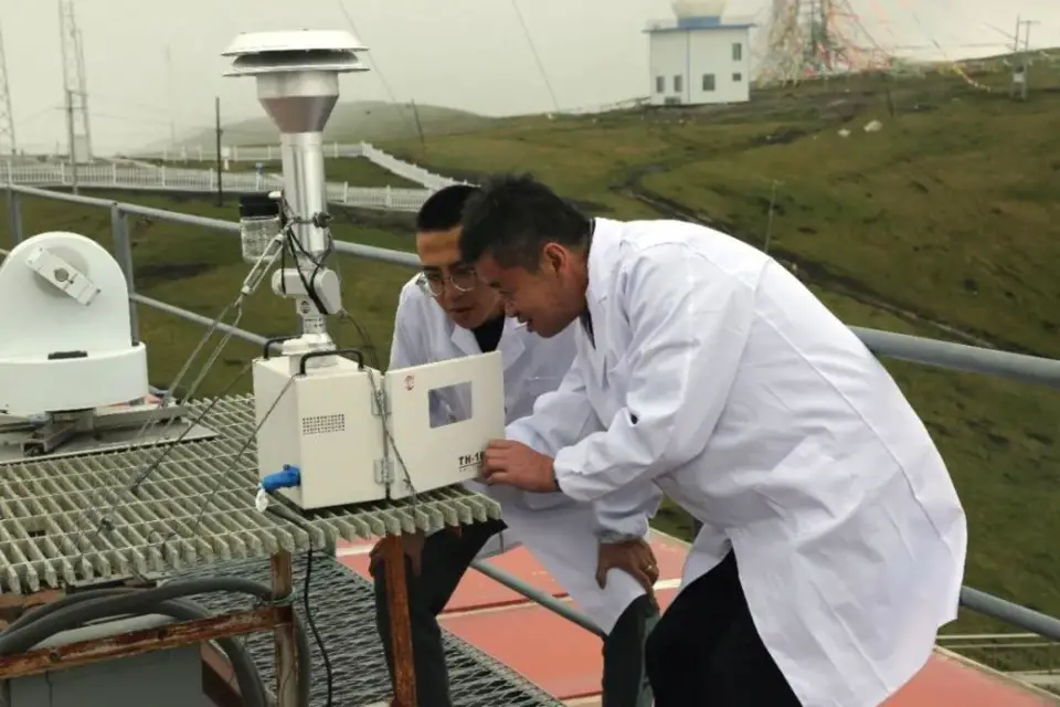 Huang Jianqing (right) and Ren Lei, observers with China Global Atmosphere Watch Baseline Observatory at Mount Waliguan in northwest China’s Qinghai province, carefully repair equipment. (Photo/China Meteorological Administration)